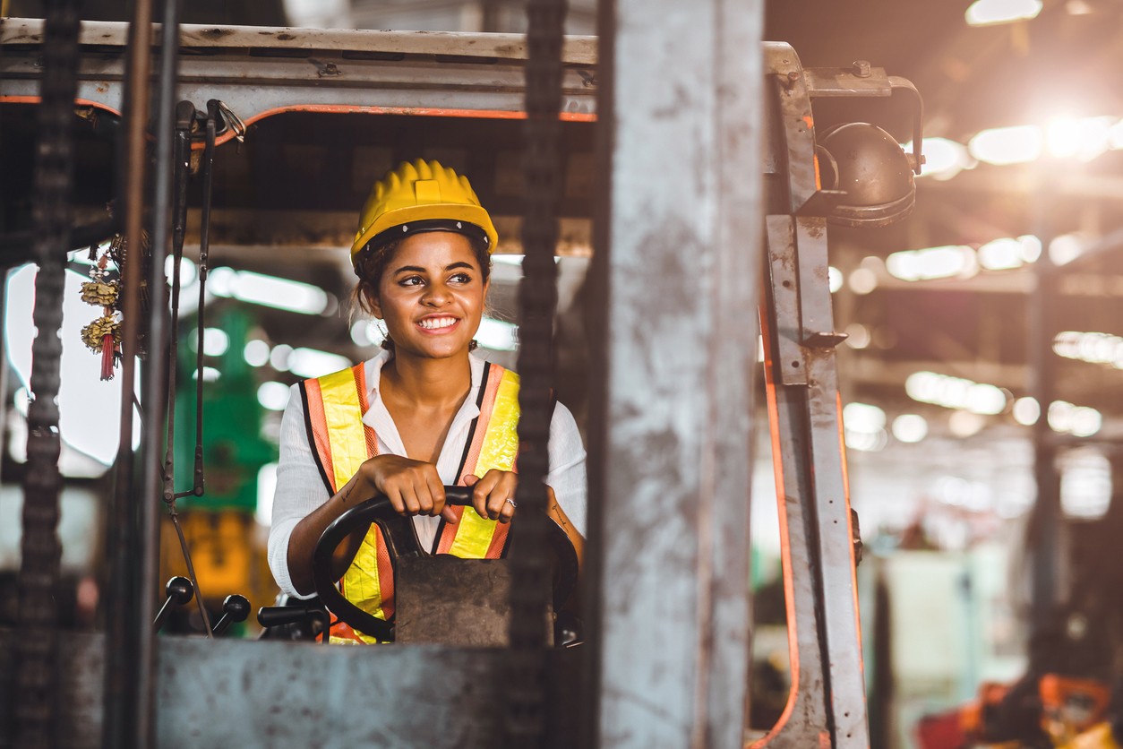 Woman smiling on forklift